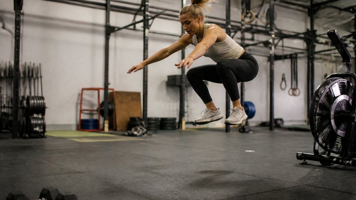 Beginner athlete performing a burpee broad jump as part of the 10 best hyrox training exercises for beginners.