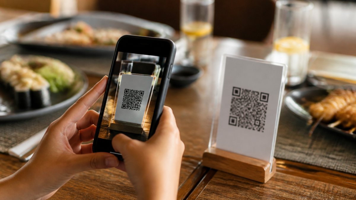 Infografía que ilustra el proceso de escaneo de un código QR para acceder a un menú digital desde el celular.