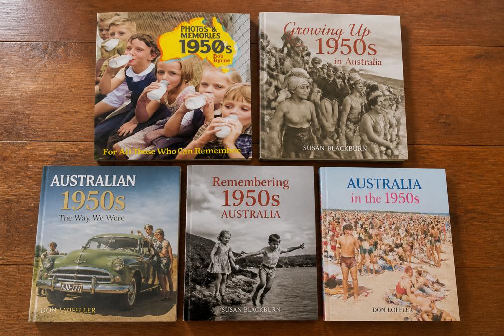 Flat lay arrangement of five Australian history books displayed together on a wooden surface, showing their covers and spines with warm natural lighting, including titles by Bob Byrne, Susan Blackburn, and Don Loffler