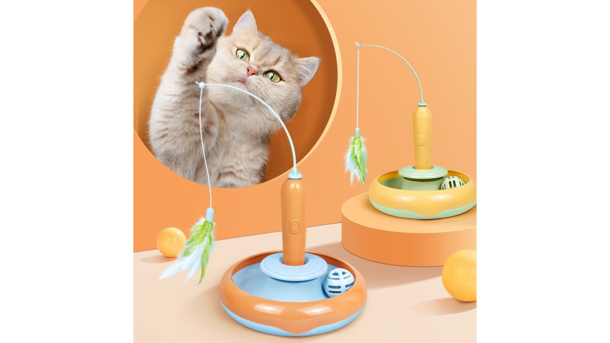 A bright, clean flat-lay photo of several colorful cat toys including a feather turntable, a plush catnip toy, and a small electronic ball, arranged neatly on a light wooden floor