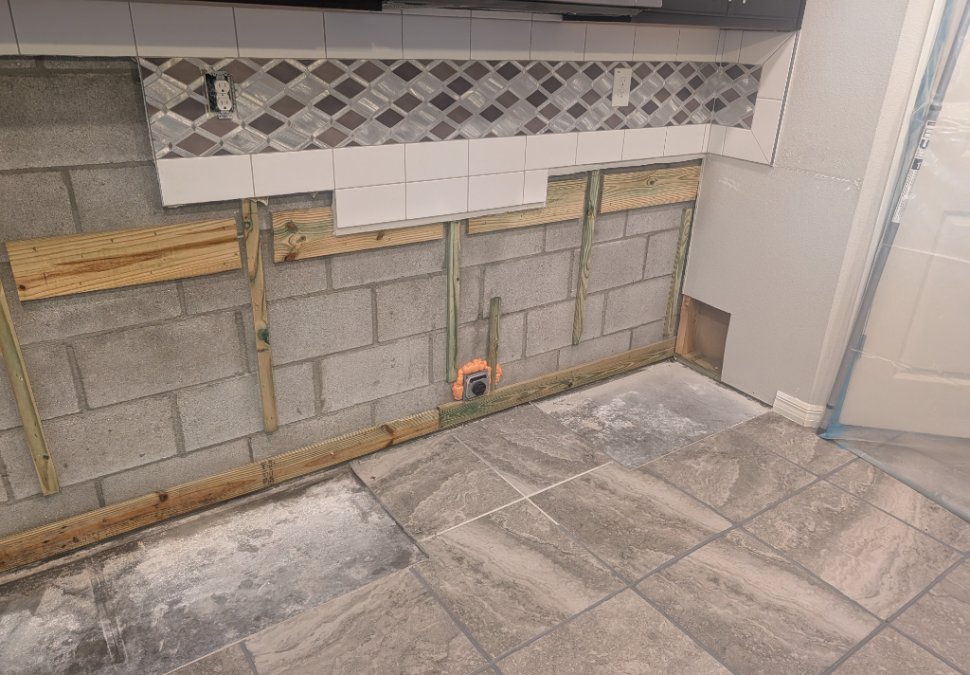 Kitchen wall area after affected cabinetry and materials were removed during mold remediation.
