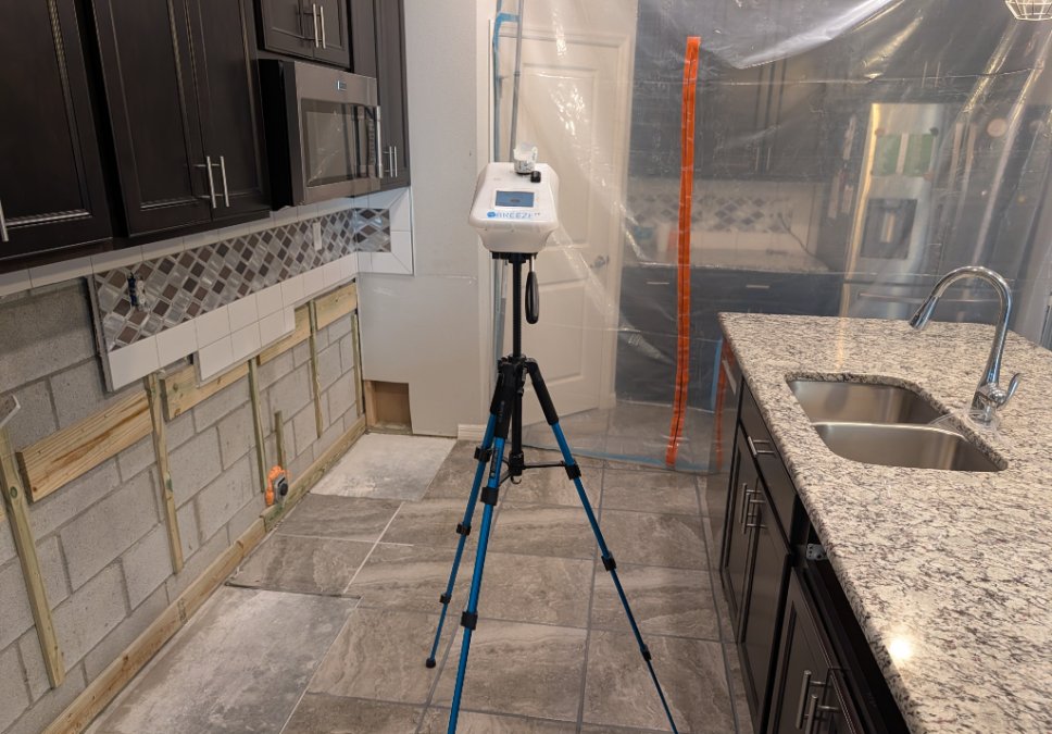 Post-remediation air testing setup inside a residential kitchen using professional air-sampling equipment after JLX remediation work.
