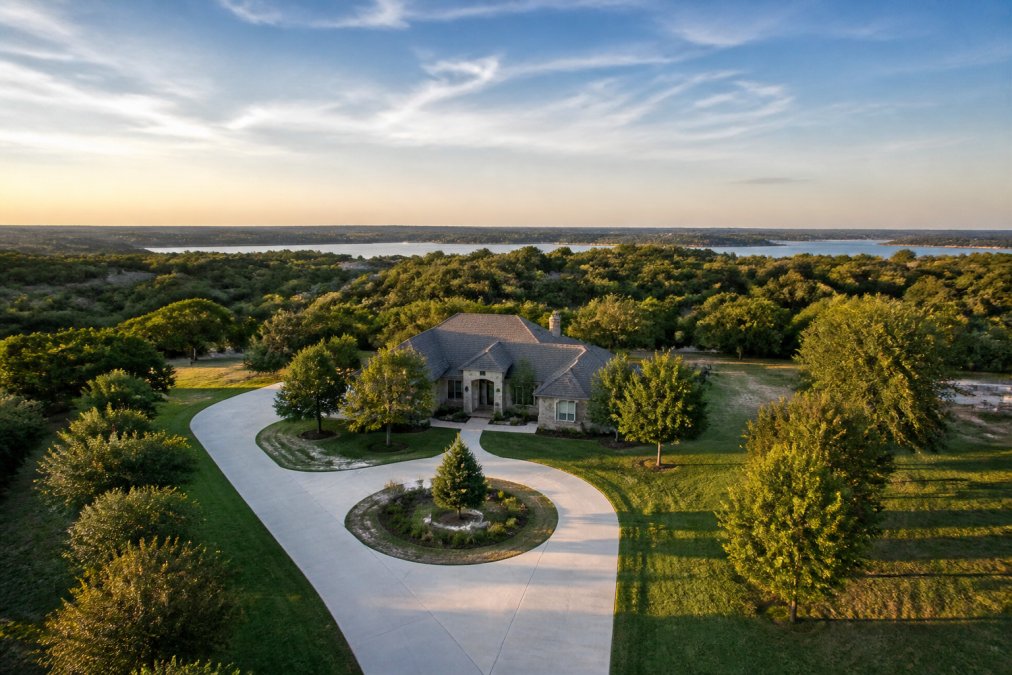 Aerial view of a residential property during late afternoon light, with the landscape showing clear rule of thirds composition, horizon line positioned in the upper third of the frame, demonstrating proper framing and visual balance for drone photography