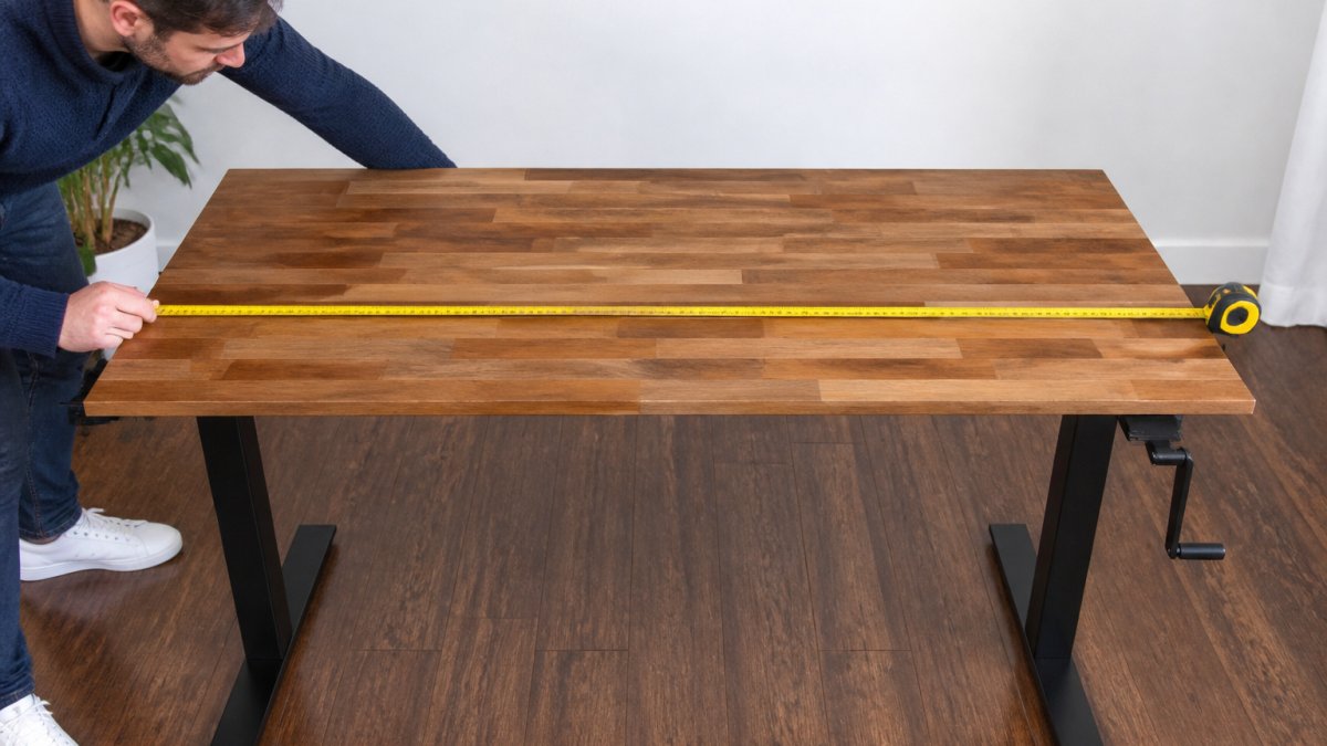 Diagram illustrating how to measure the width of a desktop between the two frame legs using a tape measure
