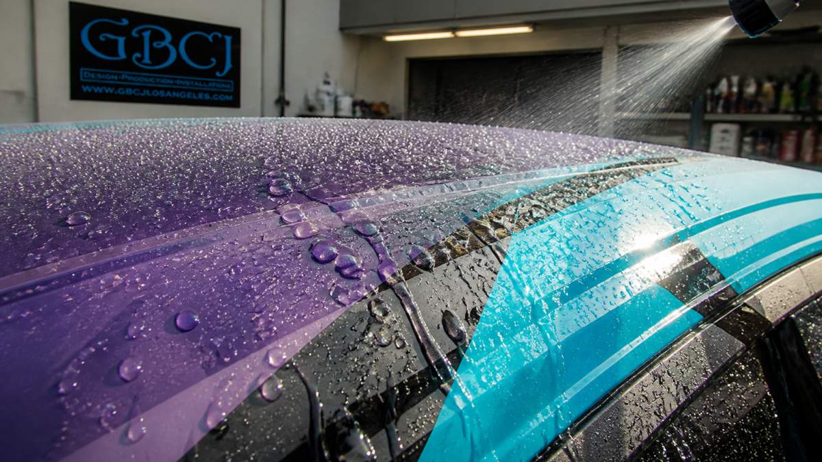 Water beads rolling off a vinyl wrap, showing the cleaning benefits of ceramic coating for vinyl wraps.