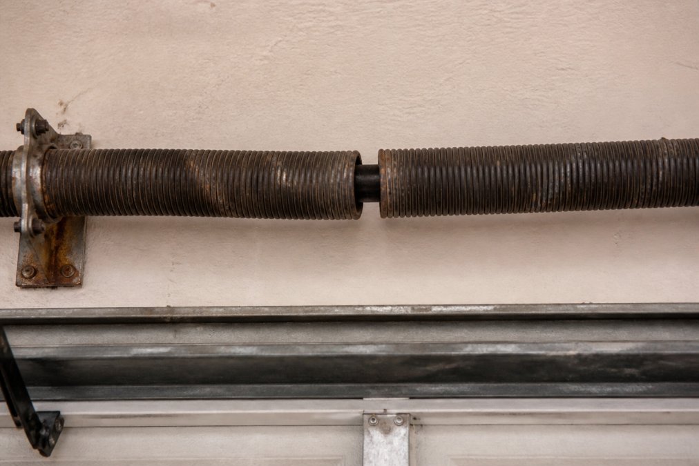 Professional illustration showing garage door spring replacement