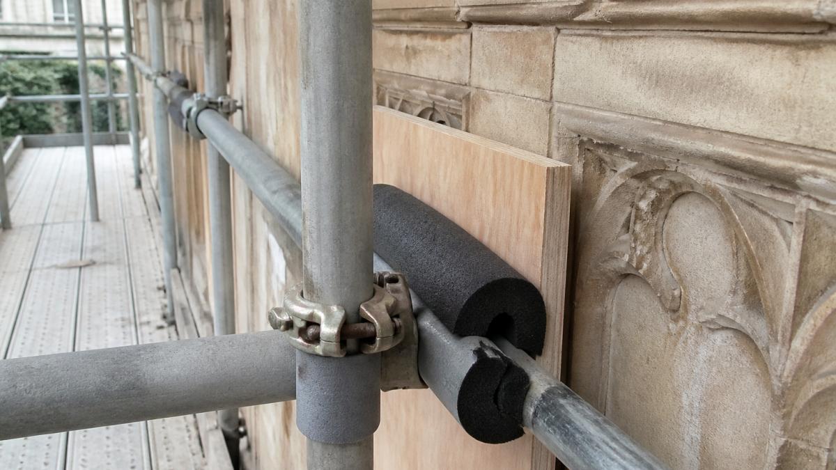 Diagram showing how foam padding and plywood protect Bath stone scaffolding against a historic masonry facade.