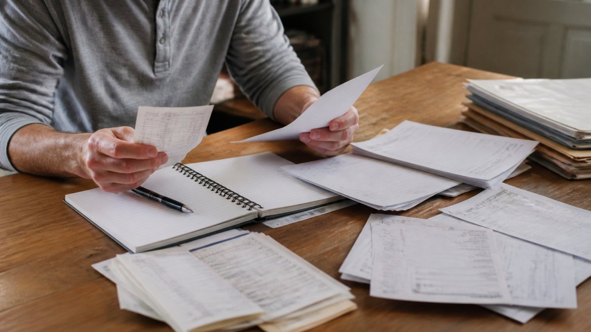Person organizing old financial documents and bank statements to prove debt is time-barred