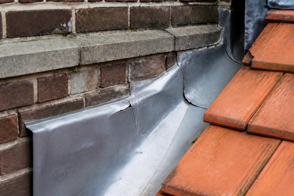Vergelijking van twee loodslab-details: links correct aangebracht met zichtbare speelruimte en flexibele clips, rechts te strak aangebracht met zichtbare scheuren en vervormingen na één winter