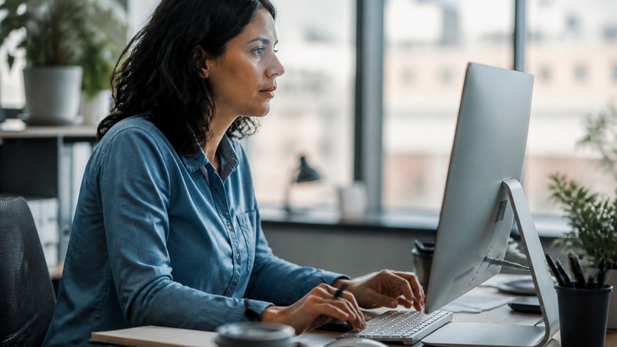 5 Ways to Automate Website Content Updates With AI Professional marketer reviewing automated content updates on a desktop monitor displaying analytics dashboard in modern office with natural window lighting