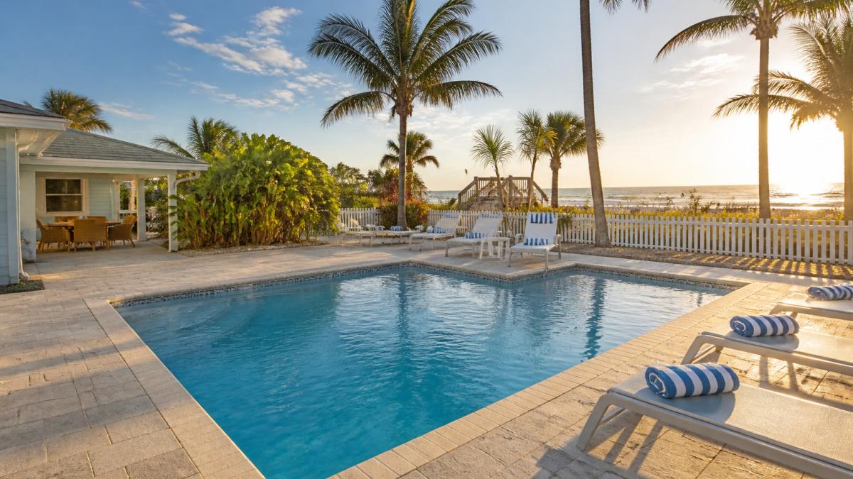 Sparkling private pool at a beach rental near Kennedy Space Center featuring lounge chairs and ocean views.