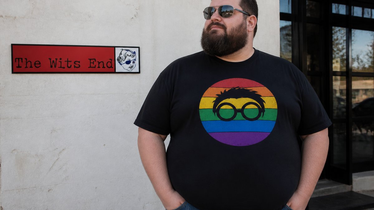 Person wearing well-fitted Rainbow Geek t-shirt in natural outdoor lighting, showing how the vibrant colors display on the fabric and proper torso coverage for a bigger frame
