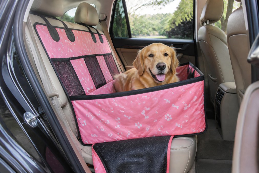Golden retriever sitting on a waterproof car seat cover in the back of an SUV, showing the non-slip backing and secure fit against vehicle upholstery with natural window lighting
