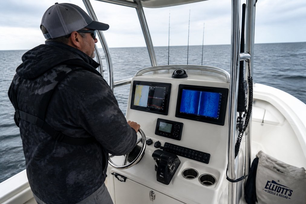 Experienced angler on a 20-foot center console boat in saltwater conditions with multiple sonar displays and GPS units mounted on the control console, showing professional-grade setup with clear viewing angles and organized cable routing