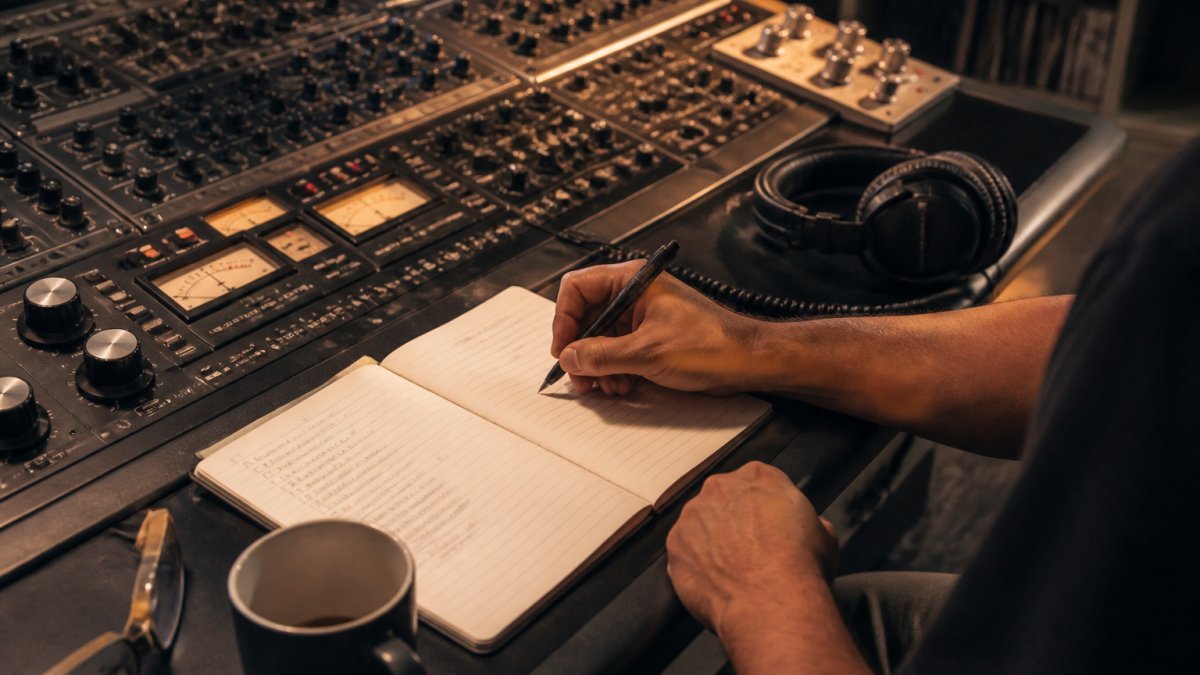 Mastering engineer listening critically to reference tracks at an analog console in a studio