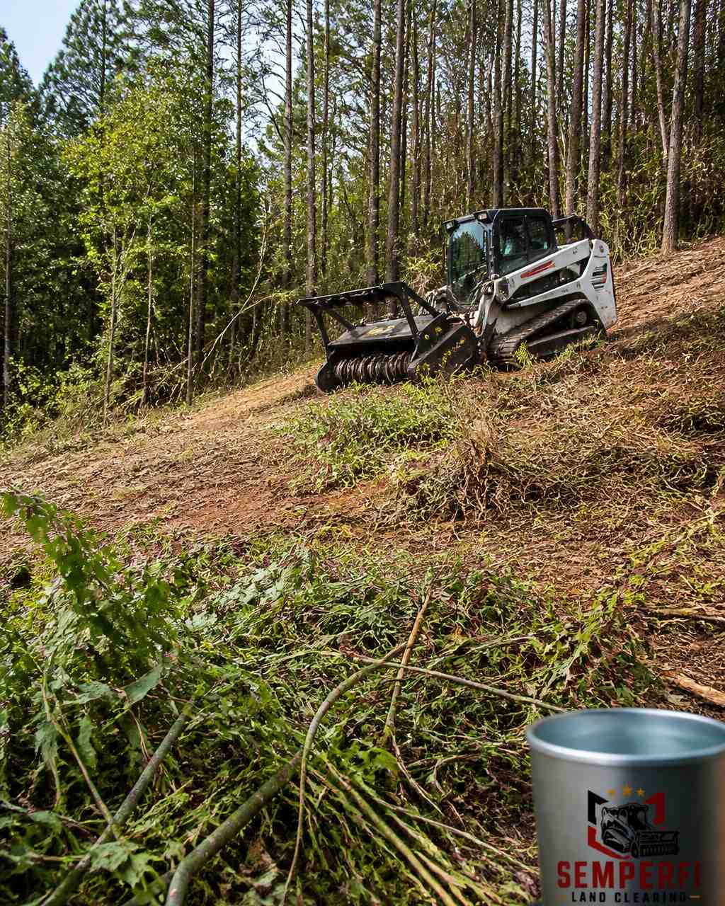 Tracked forestry mulcher clearing brush on a sloped East Texas property, impacting the total land clearing price.