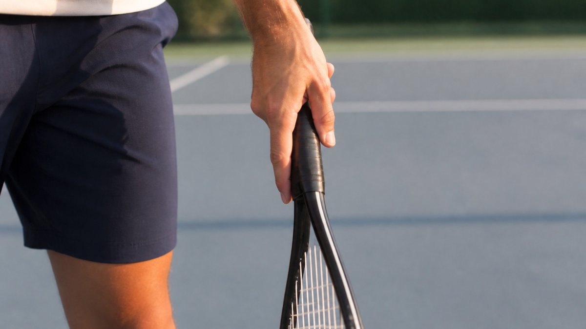 Diagram illustrating continental grip finger and wrist placement for a tennis serve spin technique.