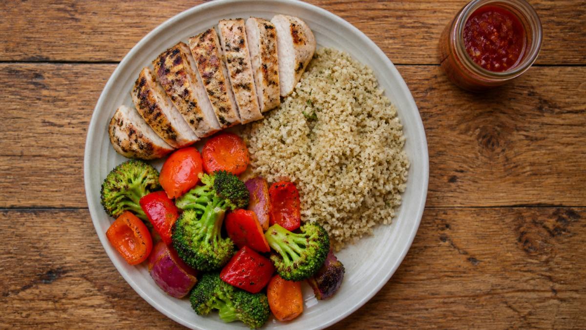 Diagram showing a balanced meal plate divided into portions of protein, vegetables, and whole grains