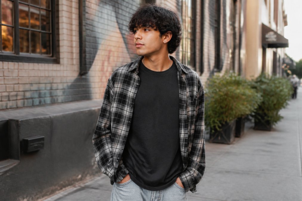 Young adult wearing a faith-inspired graphic tee and flannel in an urban setting to show 7 ways to express faith through