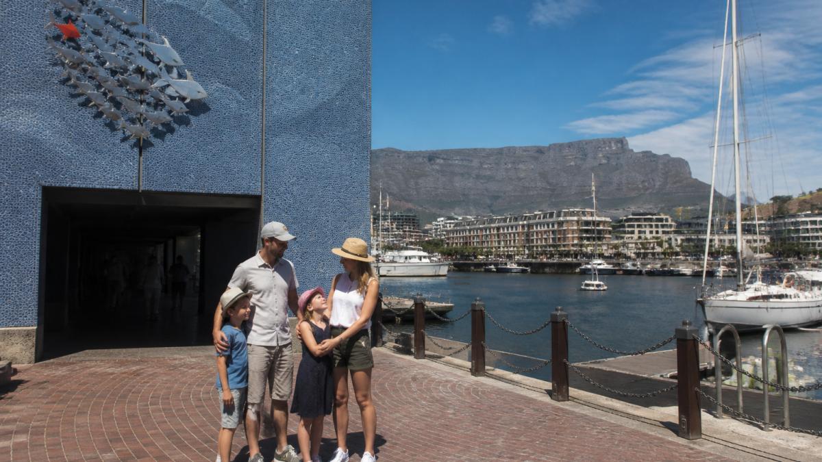 A family visits the Two Oceans Aquarium, one of the top Cape Town attractions at the V&A Waterfront harbor.