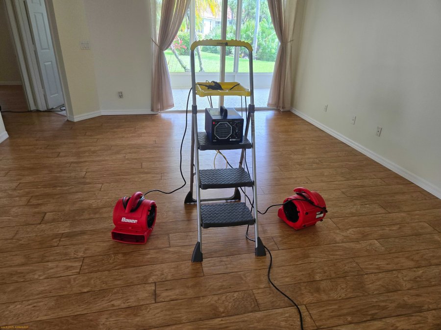 Professional ozone generator operating with air movers to help circulate ozone during a JLX odor-removal treatment inside a residential property.
