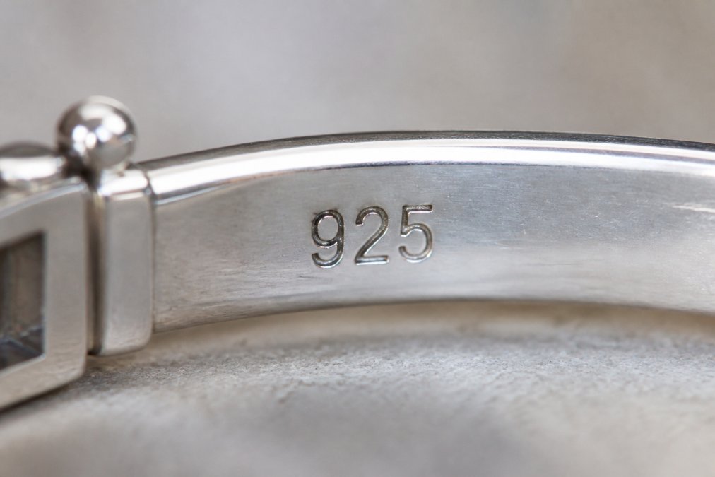 Detailaufnahme eines Silberstempels mit der Prägung '925' auf einem Schmuckstück, deutlich sichtbar und scharf fokussiert