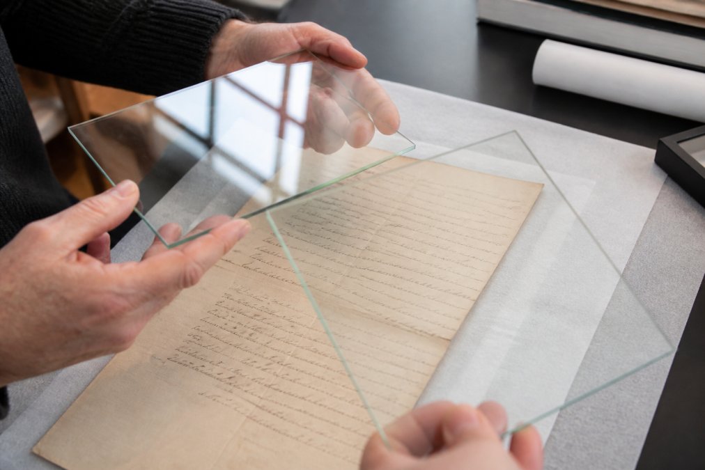Diagram comparing glare and clarity on vintage letters for acid free framing projects