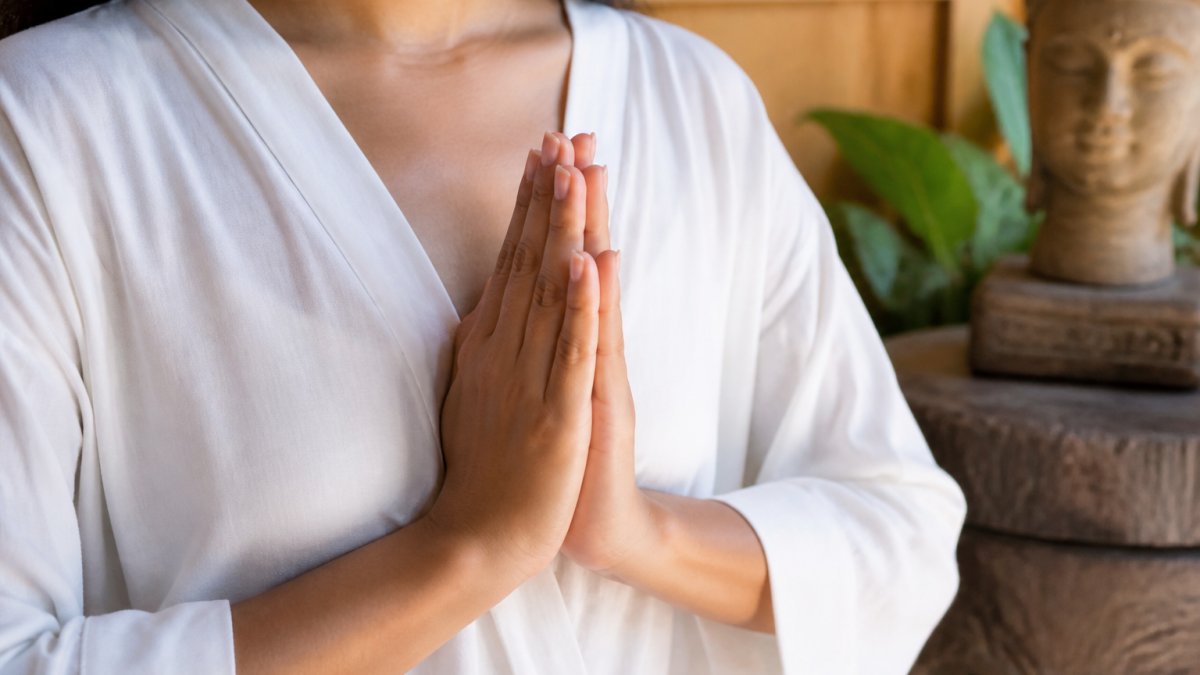 Nahaufnahme der Hände im Anjali Mudra in der Brustmitte, die Handflächen zusammengedrückt, die Finger nach oben zeigend, zeigt die richtige Ausrichtung und Fingerplatzierung bei natürlichem Licht
