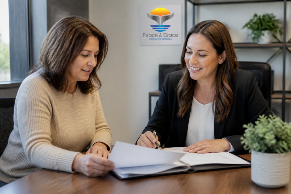 A woman in her 40s speaking with a friendly insurance consultant across a desk, both looking at paperwork, in a bright professional office setting