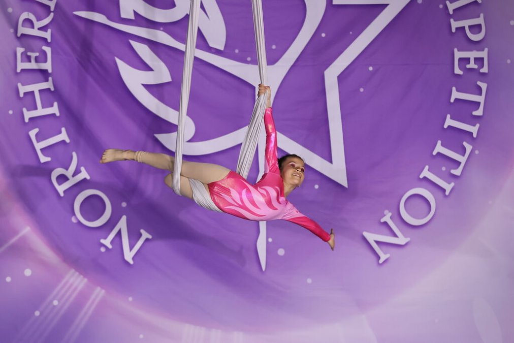 An aerial athlete from Ultimate ACRO performs a beginner pose on an aerial hammock during a competition in London, Ontario.