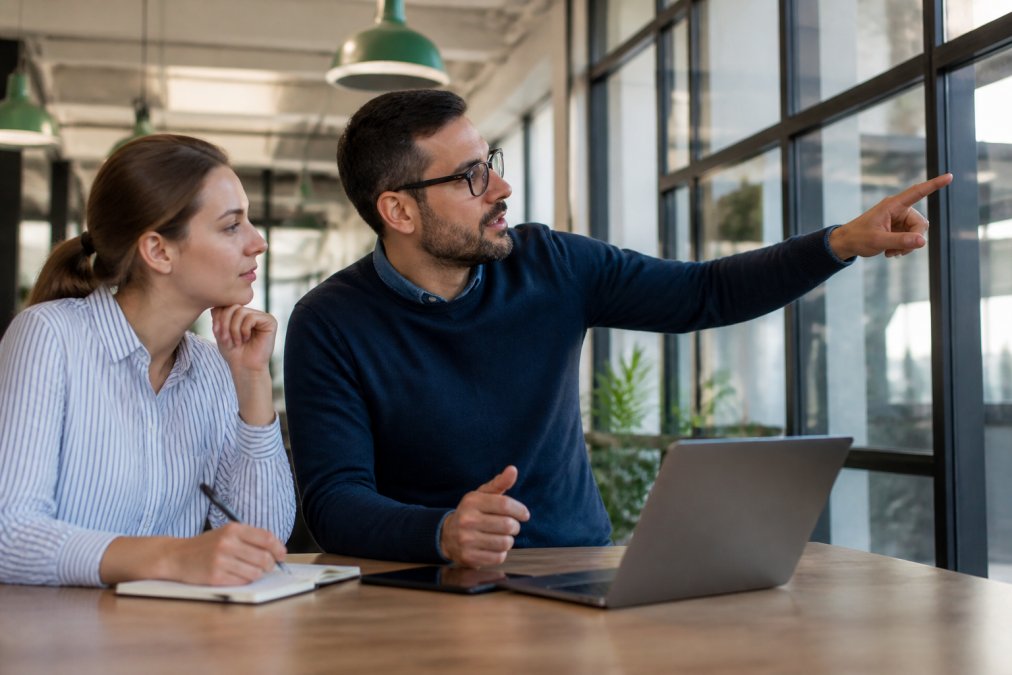 Engineering manager reviewing real-time ai agent observability dashboards with a colleague in a modern office