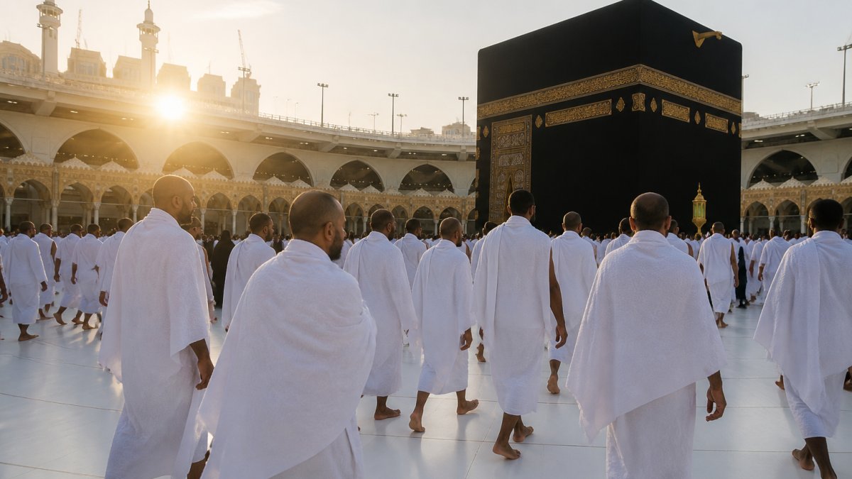 Muslim pilgrims in white ihram garments walking together near the Kaaba in the early morning light, showing the spiritual atmosphere and scale of Umrah pilgrimage