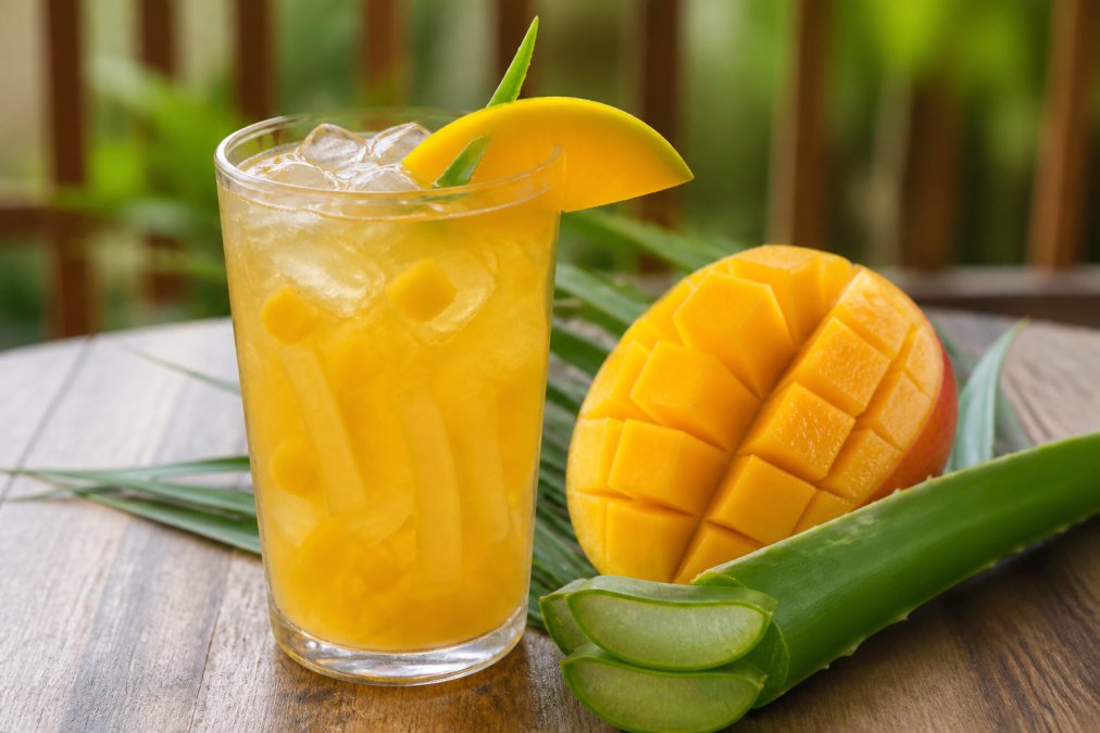 Infografik der viser ingredienser og smagsprofil i en forfriskende mango aloe vera drik med frugtstykker