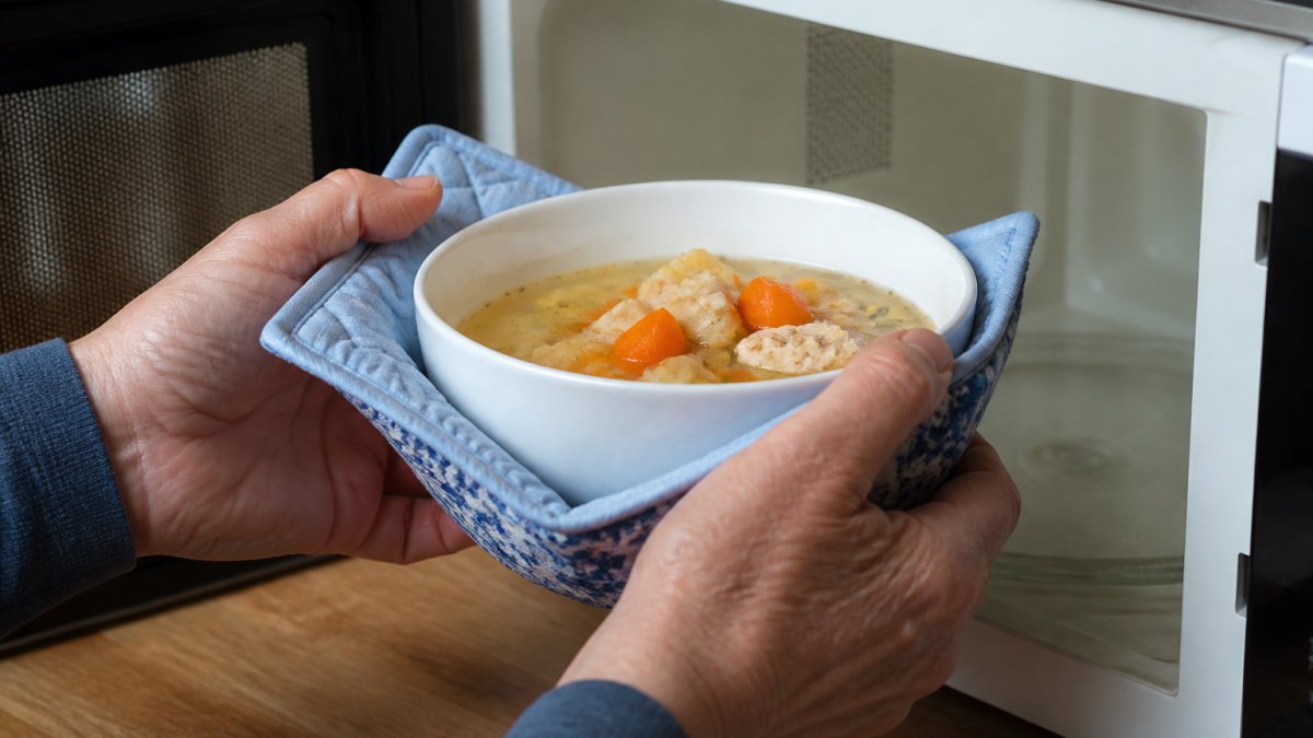 Diagram demonstrating how to use a fabric bowl cozy to safely grip a hot microwave bowl with steady hands