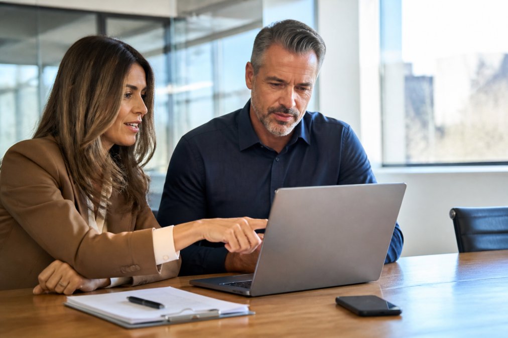 Consultant and client reviewing lead qualification data on a CRM dashboard in a modern office space