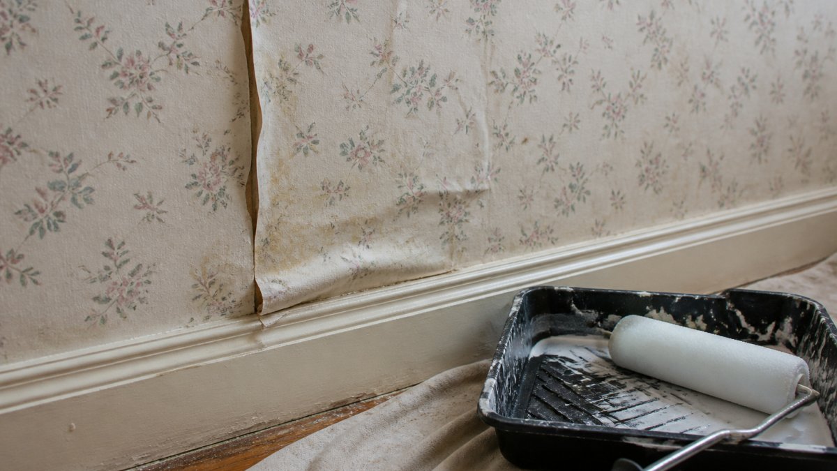 Diagram showing why painting over wallpaper fails due to peeling seams and bubbling textures on old walls.