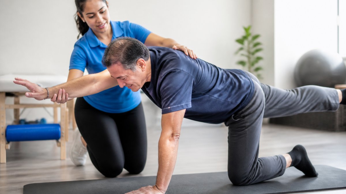 Physical therapist guiding a patient through therapeutic exercise as one of the alternatives to surgery for chronic back pain