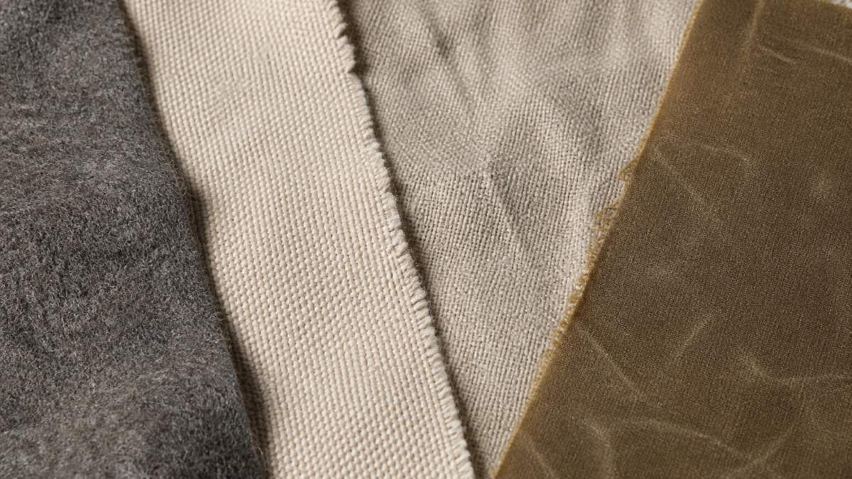 Infographic comparing textures and weave patterns of wool, cotton, linen, and waxed canvas fabric samples.