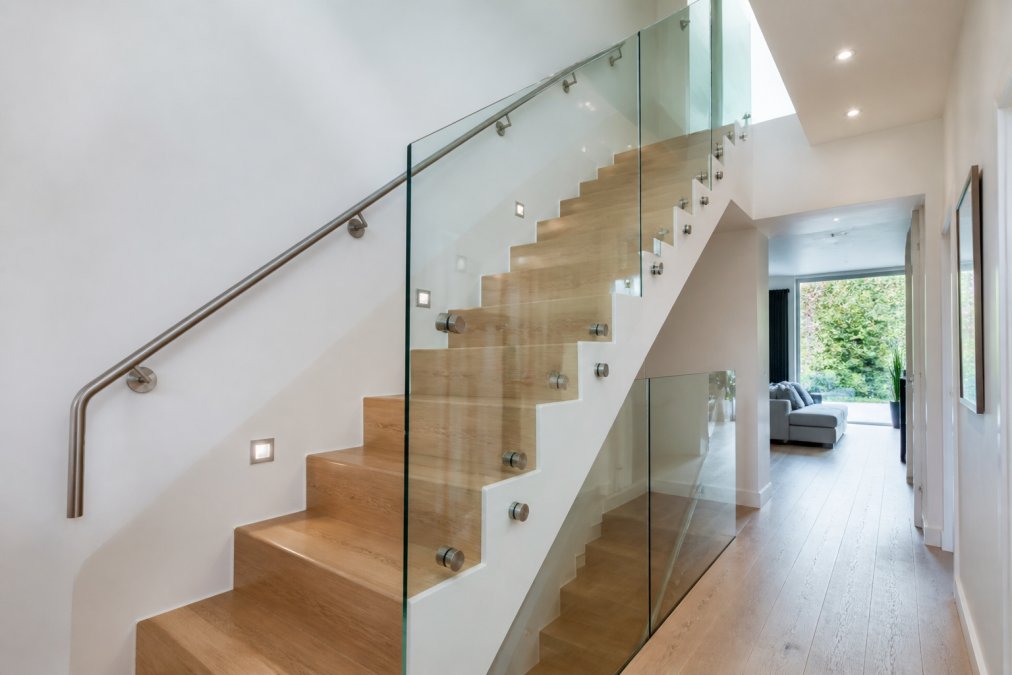 Modern hallway featuring glass balustrades and metal railings as an alternative to traditional wooden staircases