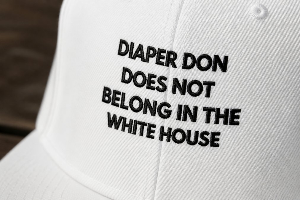 Close-up of premium cotton fabric texture on a folded anti-fascist shirt showing tight weave construction and screen-printed design detail, natural daylight revealing print durability