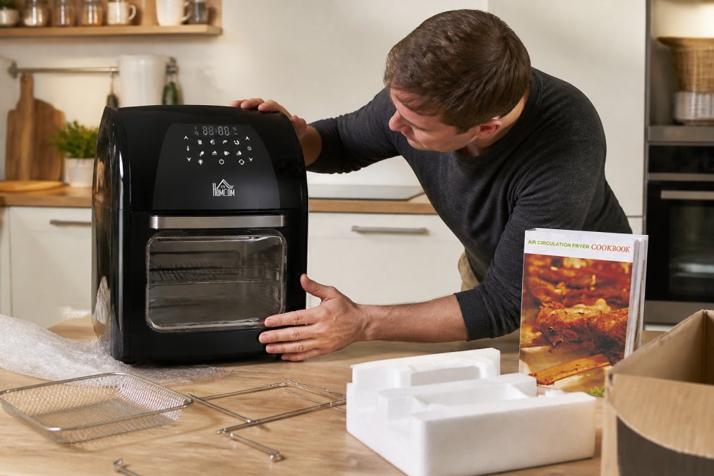 Person examining a kitchen appliance up close in a modern kitchen, checking build quality and specifications on the packaging