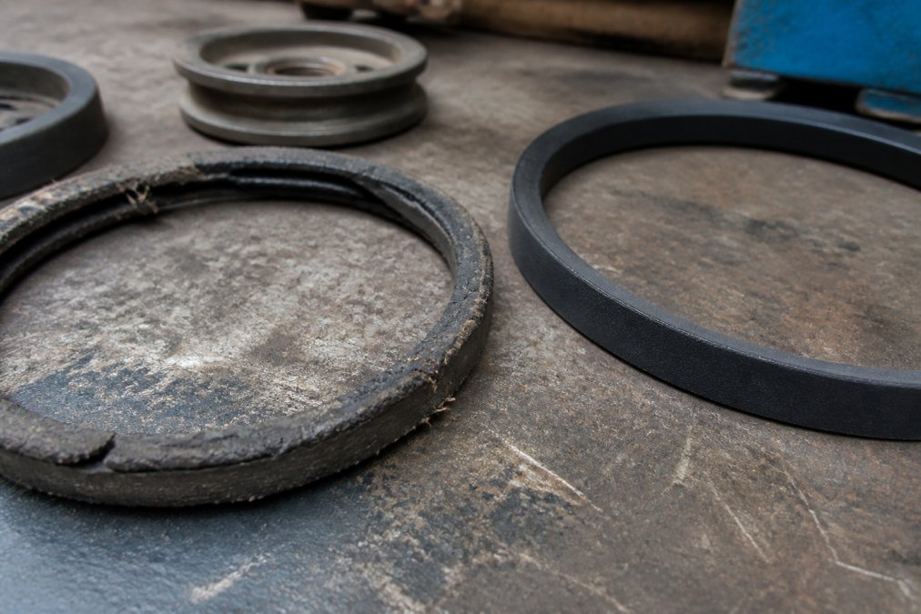 Diagram comparing a worn, cracked belt to a new one to show the premature failure of cheaper v-belts.