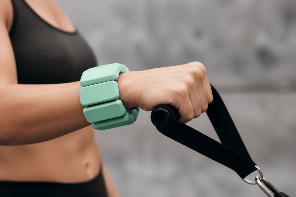 Close-up of a person's wrist and forearm showing proper band placement with correct alignment during an exercise, highlighting secure positioning and neutral wrist angle