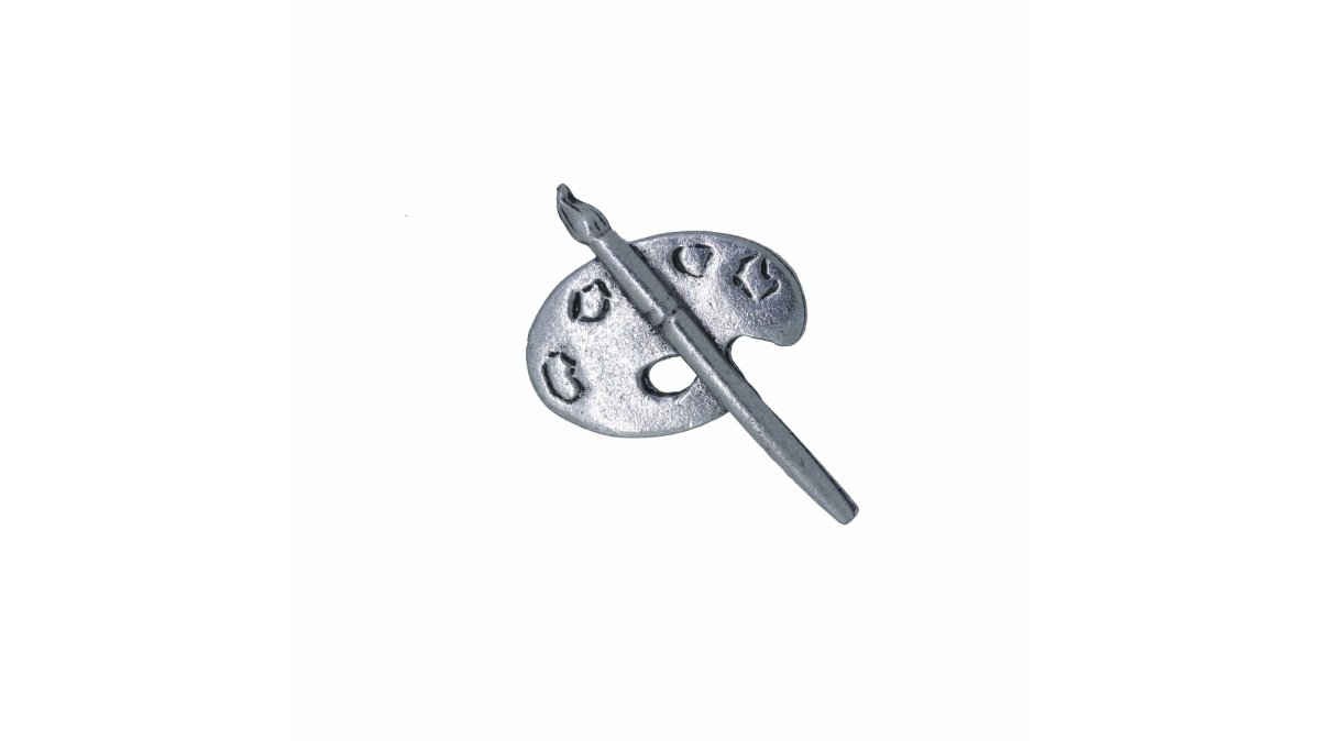 Close-up of a hand holding a handcrafted pewter artist palette lapel pin, showing the sculpted three-dimensional detail and brushed metal finish against a soft neutral studio background