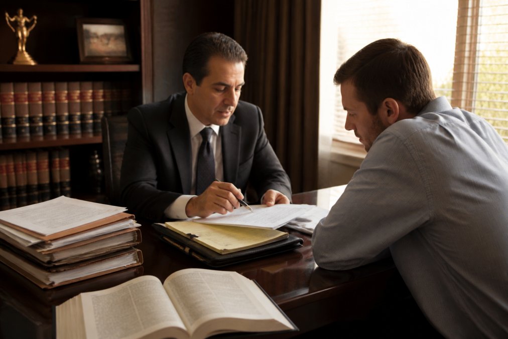 Assault and battery lawyers consulting with a client to discuss legal strategy in a professional office.