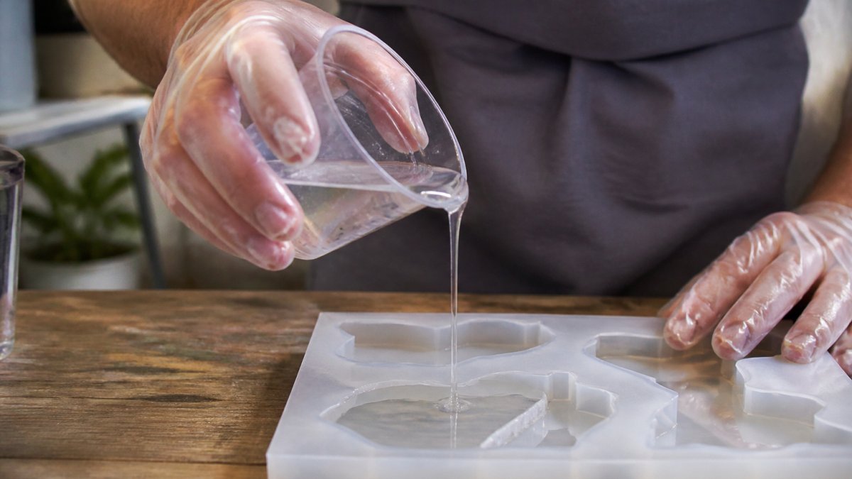 Step-by-step diagram for avoiding bubbles in resin by pouring a thin, controlled stream into a silicone mold