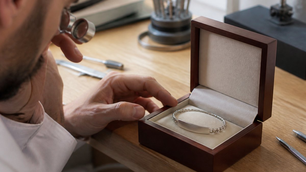 Professional examining a high-quality personalized jewelry piece, showing fine engraving details and smooth finish in natural lighting