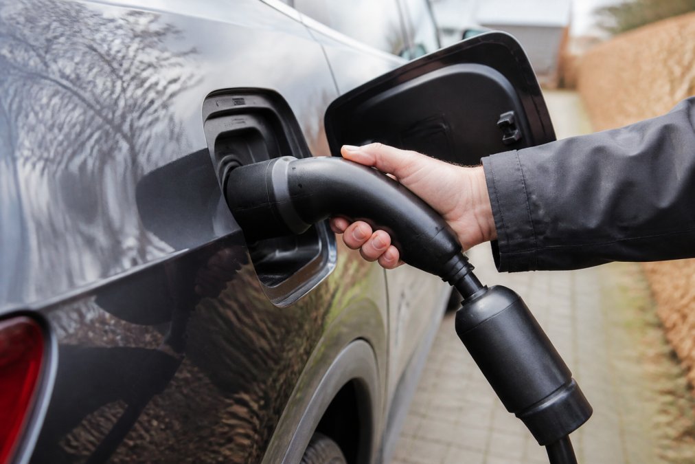Posnetek od blizu adapterja V2L, priključenega na polnilno vtičnico tipa 2 na električnem avtomobilu, ročno preverjanje povezave zagotavlja povezavo.