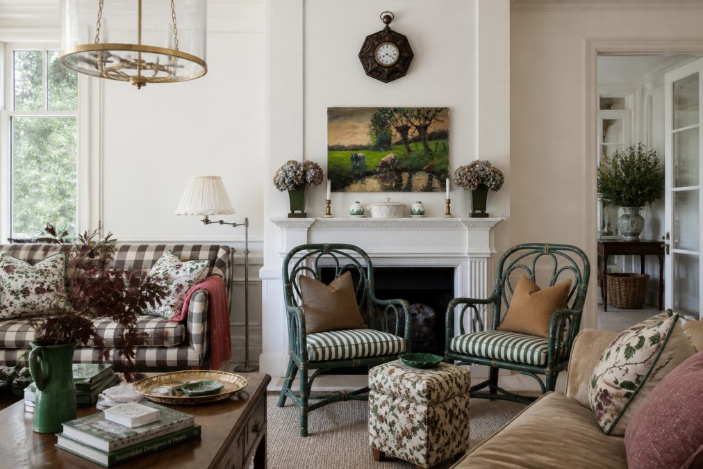 A sophisticated living room interior with designer pendant lighting, carefully arranged luxury furniture pieces in complementary finishes, and curated decor creating visual harmony and spatial balance