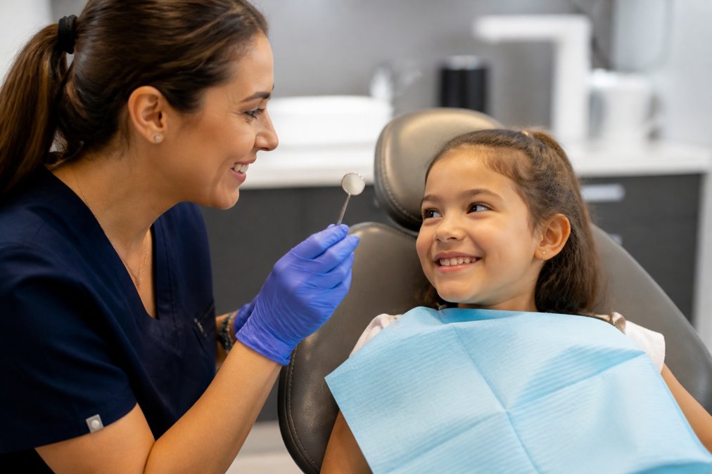 Infographic illustrating the step-by-step procedure for applying dental sealants on a smiling child in a dental office.